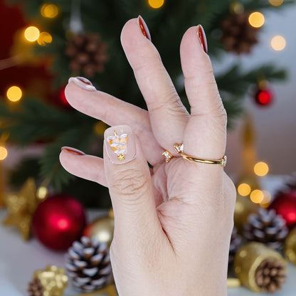 Detailed thumb close-up showing white Christmas tree on translucent base