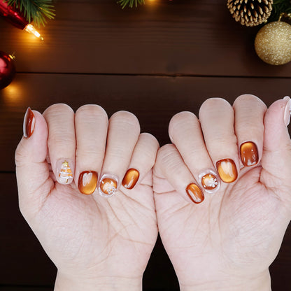 Shiny holiday nails with snowflake and gold accents against festive decor