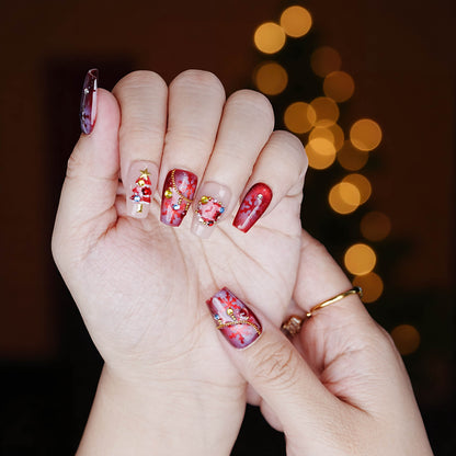 Full hand set of red Christmas press on nails featuring tree charms, gem wreath, and snowflake detail