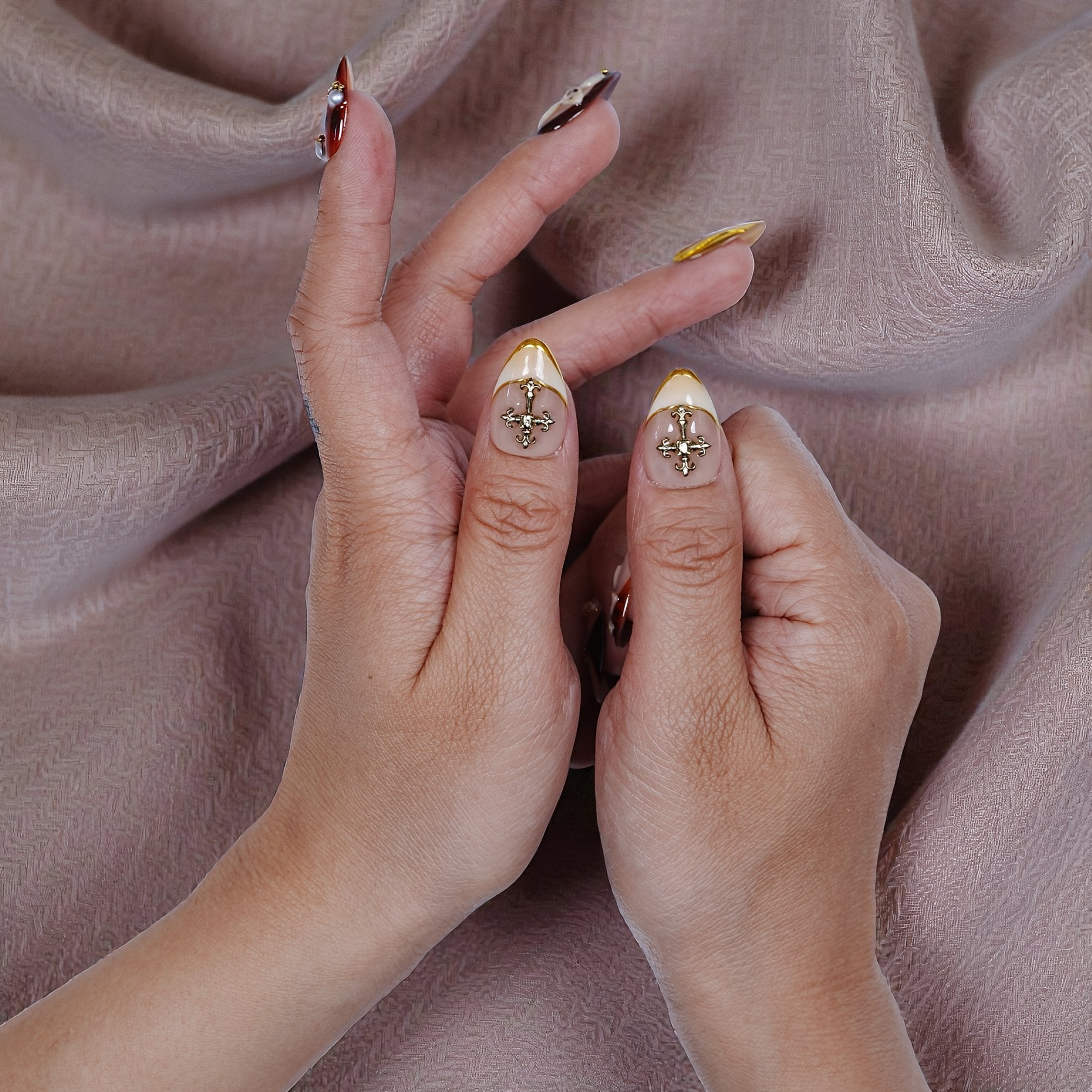 Close up of luxury press on nails with gold charm embellishments