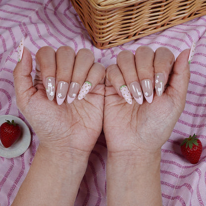 Handmade press on nails with strawberry and floral designs, pink striped fabric, strawberries