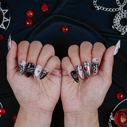 Handmade black, silver, and red press on nails with 3D heart and gem accents on hands