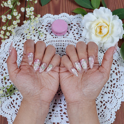 Handmade press on nails with pink floral design on hands, styled with lace and flowers