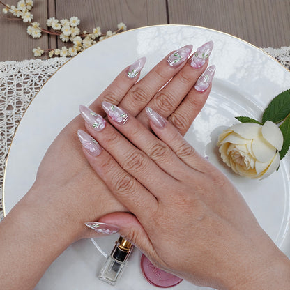 Hand with premium handmade press on nails featuring pink floral design on white plate
