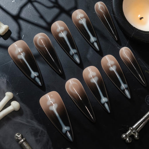 Graveyard Shift skeleton press on nails, black ombre stiletto set with white bones and crescent moons for Halloween