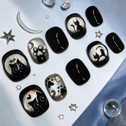 Midnight Paws cat paw press on nails, short glossy black set with silver cat eye moons, cat silhouettes and a raised 3D paw