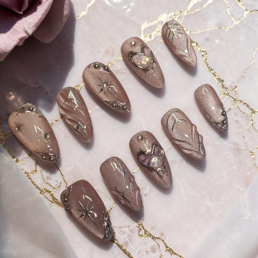 Mocha Starlight brown press on nails, almond set with mocha cat eye shimmer, silver chrome lines, starbursts and 3D opal hearts