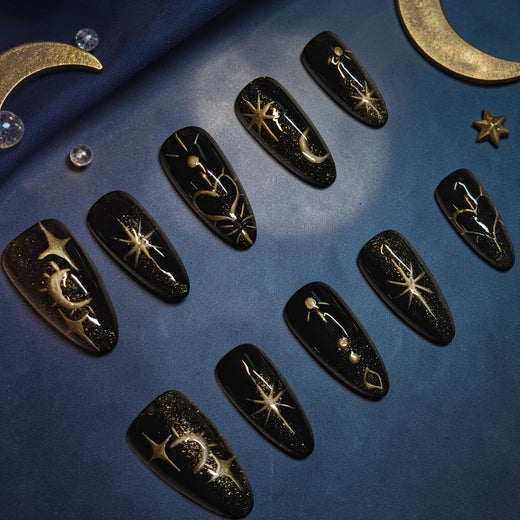 Golden Eclipse celestial press on nails, glossy black almond set with gold glitter, raised gold stars, crescent moons and planets