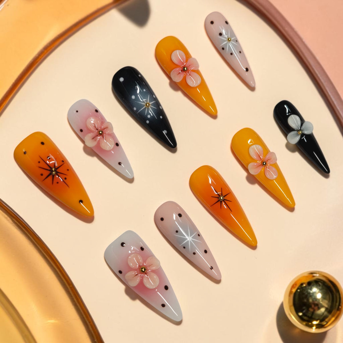 Pumpkin Blossom orange press on nails, long stiletto Halloween set with black starbursts, gold beads and 3D pink flowers